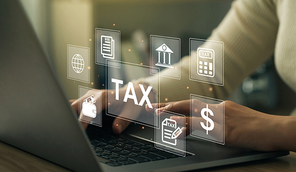 Hands typing on a laptop with digital tax-related icons floating above the keyboard, to symbolize estate tax planning