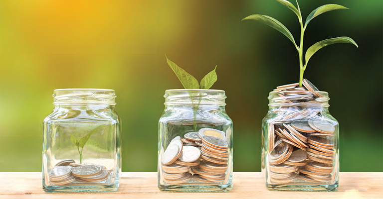 Three glass jars filled with coins and growing plants, symbolizing financial growth
