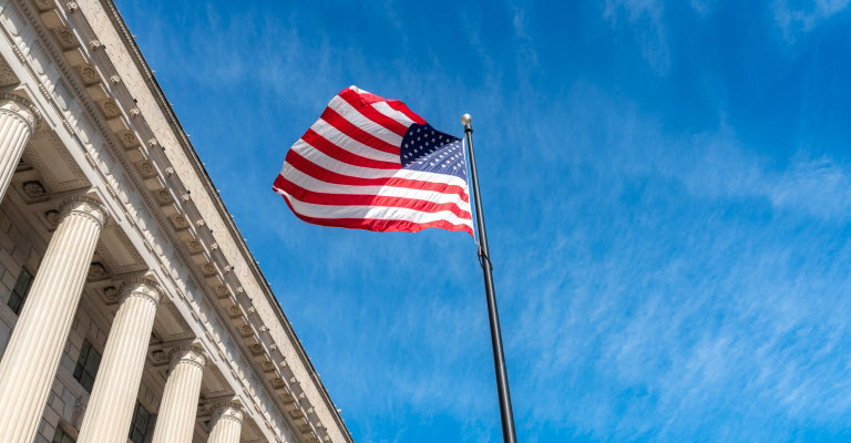 U.S. flag flying in front of a courthouse, suggesting a landmark legal decision