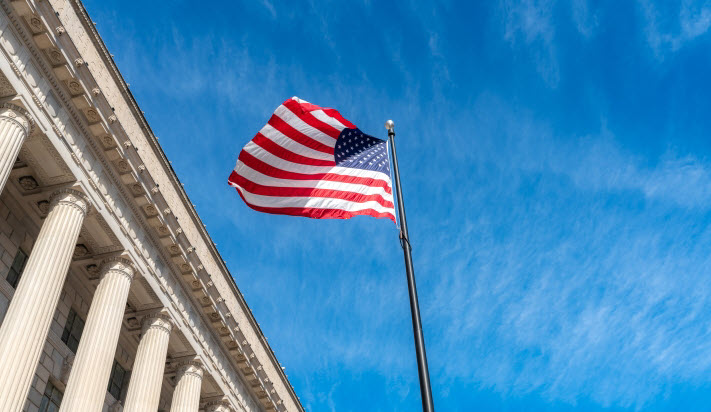 U.S. flag flying in front of a courthouse, suggesting a landmark legal decision